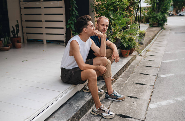 Gay Couple spend time together outdoors. Homosexual couple sitting outdoors - Foto, Imagen