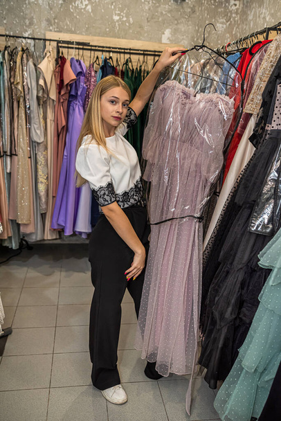 jovem mulher feliz escolher e experimentar roupas durante as compras em boutique, estilo de vida elegante - Foto, Imagem