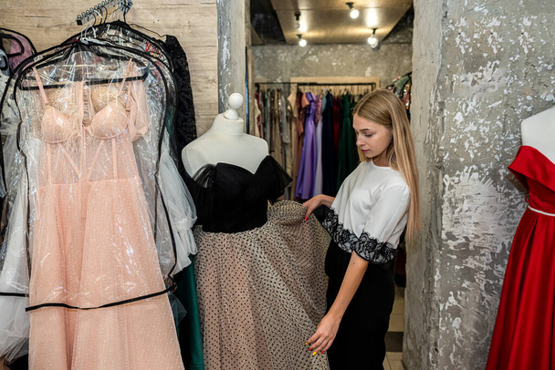 Beautiful woman choosing evening dress for rent at garment supermarket - Fotografie, Obrázek