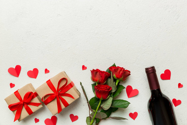 Valentine's day composition with red wine, rose flower and gift box on table. Top view, flat lay. Holiday concept. - 写真・画像