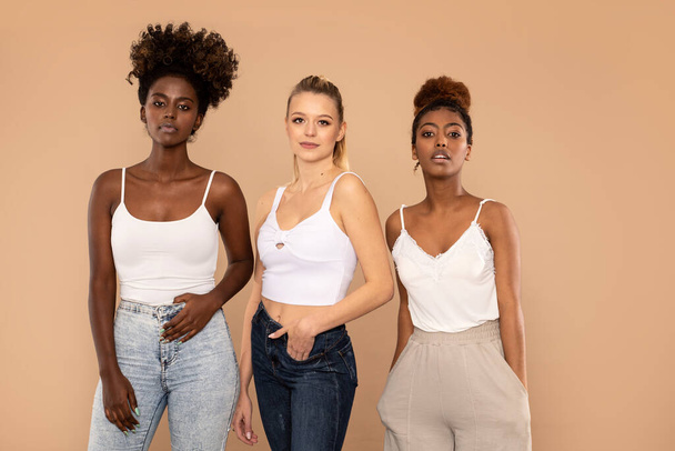 Group of friends of different race. Diverse women posing together. Multi ethnic females looking at camera in studio. Fashionable photo - Photo, Image