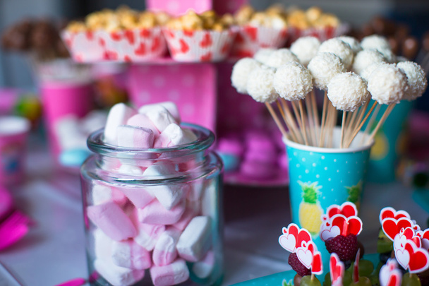Ibišek, barevné sladké pusinky, popcorn, pudinkové zákusky a koláče se objeví na stole - Fotografie, Obrázek