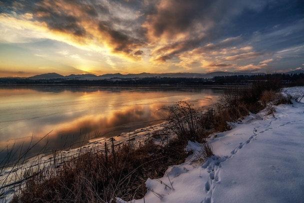 Beautiful colorful sky during sunrise on cold winter morning. Frozen water on dam Liptovska Mara, Slovakia. - Foto, immagini