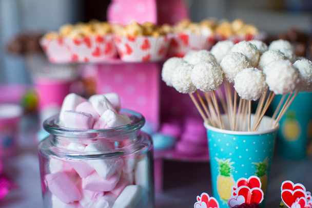Ibišek, barevné sladké pusinky, popcorn, pudinkové zákusky a koláče se objeví na stole - Fotografie, Obrázek