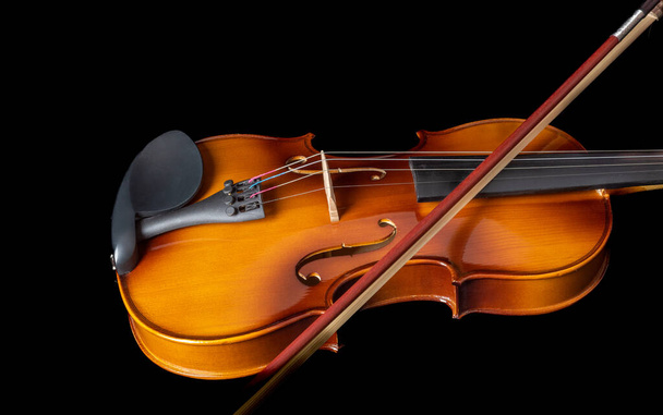 Violin with bow on strings isolated on black background. - Foto, Imagen