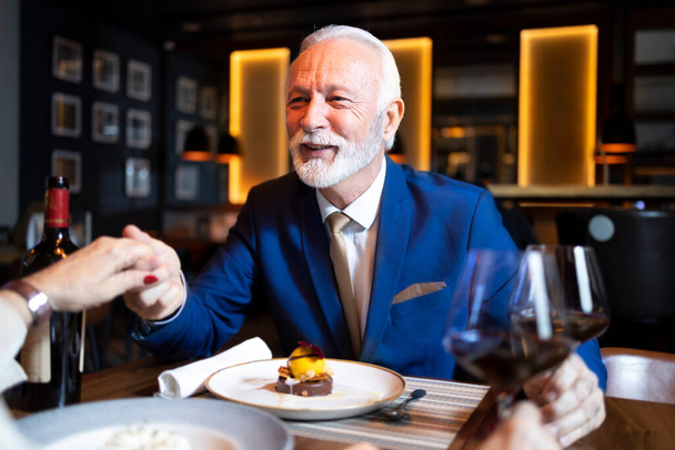 Elegante hombre de negocios en un traje cenando con su pareja - Foto, Imagen