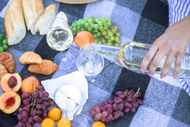 piknik w przyrodzie, dziewczyna i mężczyzna trzymają kieliszki w rękach z winem. Skupienie selektywne - Zdjęcie, obraz