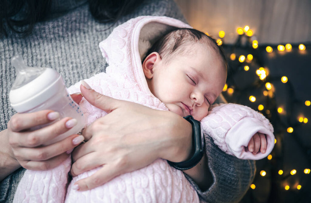 Yeni doğmuş tatlı bir kız bebek annesinin kollarında uyuyor.. - Fotoğraf, Görsel