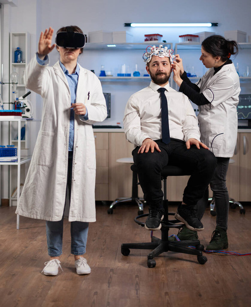 Mujer investigadora que usa auriculares de realidad virtual durante el experimento de neurología - Foto, imagen