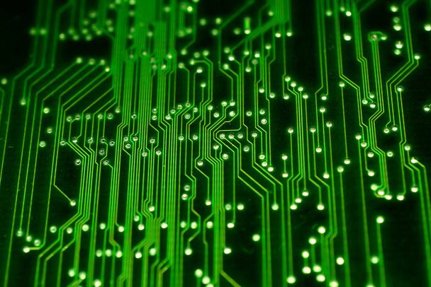 この写真は、緑色の電子回路基板とテクスチャパターンを作成する電気ラインのクローズアップを示しています。. - 写真・画像