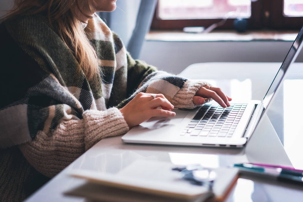 Freelance student meisje werkt thuis zitten aan tafel met koffie met behulp van laptop, online werk en onderwijs - Foto, afbeelding