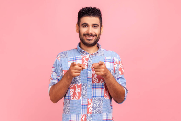 Hey you! Portrait of cheerful bearded man in blue casual style shirt pointing to camera, smiling, making happy choice, we need you concept Indoor studio shot isolated on pink background. - Fotoğraf, Görsel