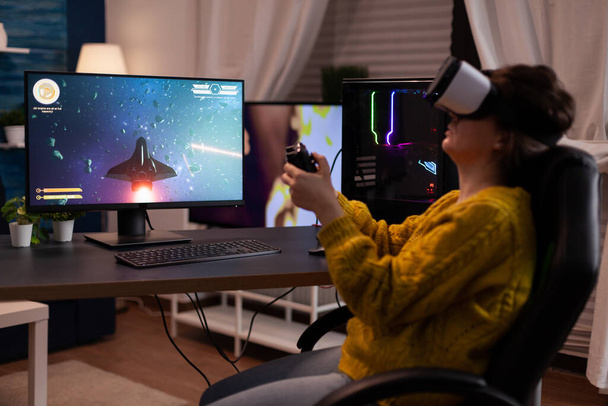 Hráč žena nosí brýle virtuální reality při hraní prostor střelec videohry - Fotografie, Obrázek