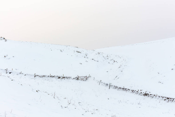 Vista de invierno del campo cubierto de nieve con paredes de piedra seca. Peak District, Derbyshire, Reino Unido. - Foto, imagen