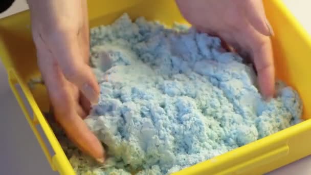 Vrouwelijke handen spelen met blauw kinetisch magisch zand. Anti stress relaxatie activiteit - Video