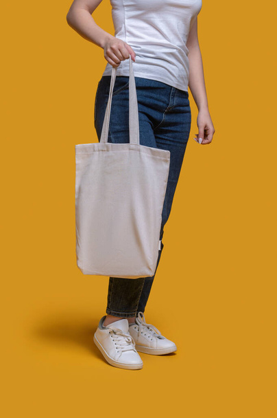 Female demonstrating her stylish bag before the camera - Photo, image
