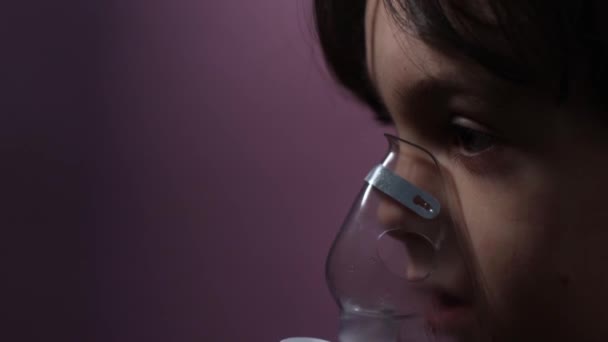el niño inhala, el niño inhala el medicamento a través de la máscara - Metraje, vídeo
