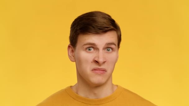 Disgusted Man Grimacing Smelling Bad Stink Standing Over Yellow Background - Video