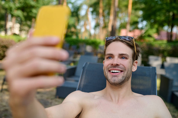 A smiling man making selfie and looking excited - Фото, зображення