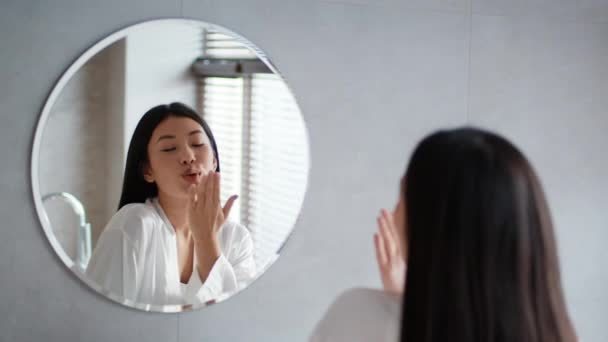 Asian Female Blowing Kiss To Reflection In Mirror In Bathroom - Záběry, video