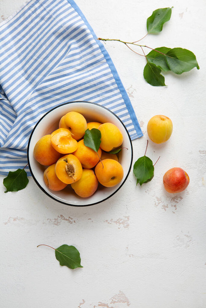 Fresh apricots fruit in bowl on white kitchen table food top view - Foto, Imagem