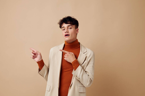 A young man in a beige jacket talking on the phone isolated background unaltered - Foto, immagini
