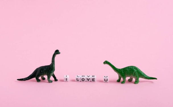 Cute  little green dinosaurs and the inscription I love you on a pink background. Saint Valentine's day card. - Photo, image