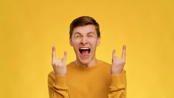Συναισθηματικός τύπος Εμφάνιση Rock Gesture Φωνάζοντας στο κίτρινο φόντο - Πλάνα, βίντεο