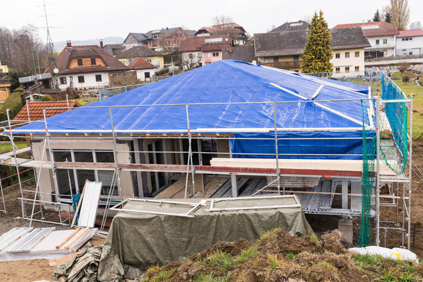 Construction de maisons de plain-pied dans la phase de construction de la coquille avec échafaudage et couverture de toit - Photo, image