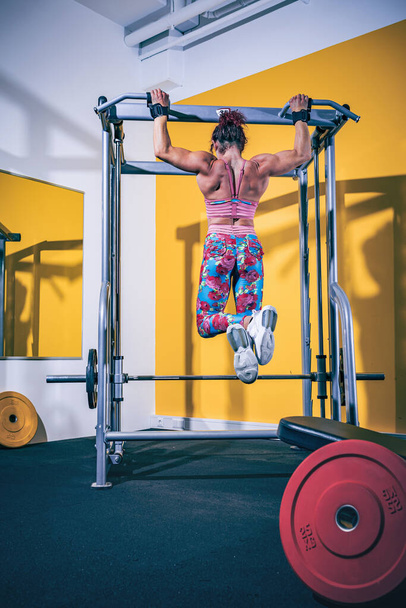 a woman working out with pull-up bar in the gym or fitness room - Foto, immagini