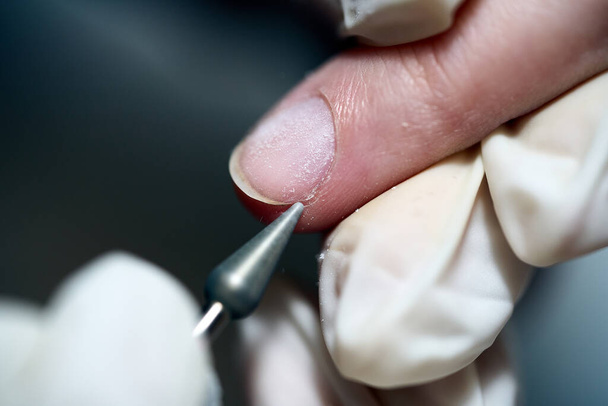 Manicure procedure in salon with electric nail drill machine. Close-up shot. - Foto, Bild