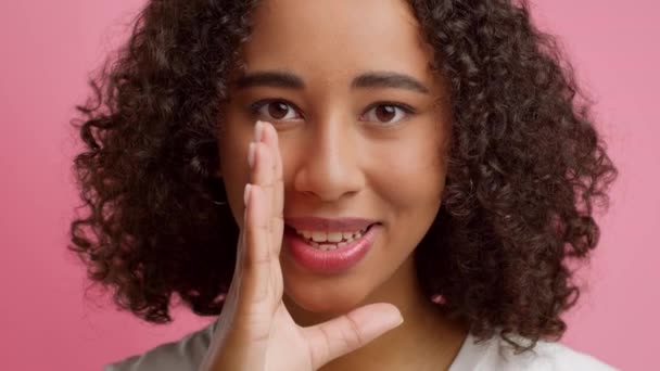 Black Woman Whispering Sharing Secret Over Pink Background - Materiał filmowy, wideo