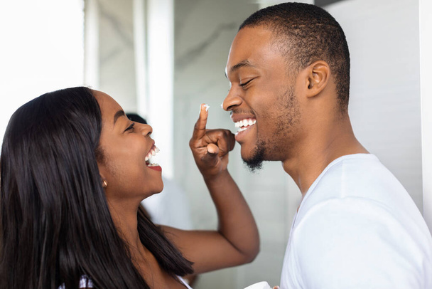 Gros plan de heureux couple afro-américain s'amuser dans la salle de bain - Photo, image