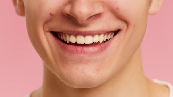 Ανδρικό πρόσωπο χαμογελώντας Εμφάνιση λευκά δόντια πάνω από ροζ φόντο, περικοπεί - Πλάνα, βίντεο