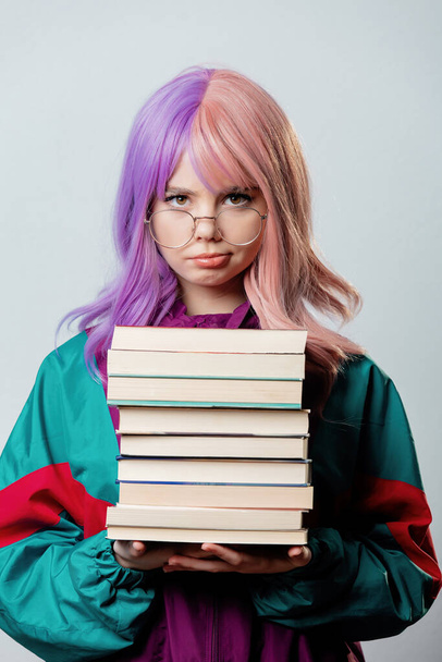 Beautiful yandere girl with purple hair and 80s tracksuit holds book on gray background - Fotó, kép
