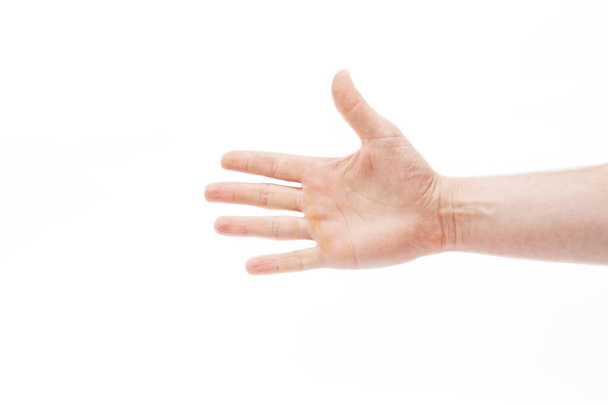 Το ανοιχτό χέρι ενός άντρα σε λευκό φόντο απλώνεται μπροστά. Και τα πέντε δάχτυλα είναι ξεκάθαρα ορατά. Μεμονωμένα - Φωτογραφία, εικόνα