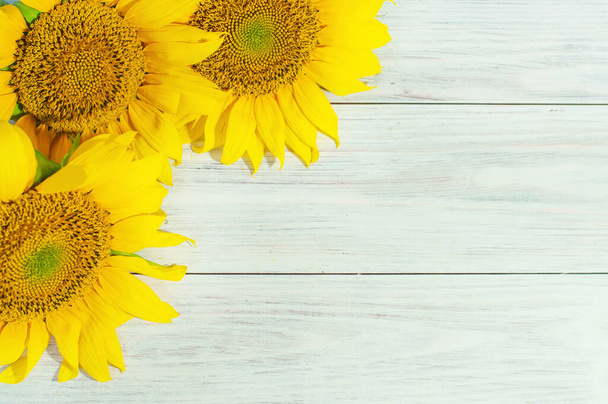 bouquet of yellow sunflowers on a light wooden background with space for text - 写真・画像