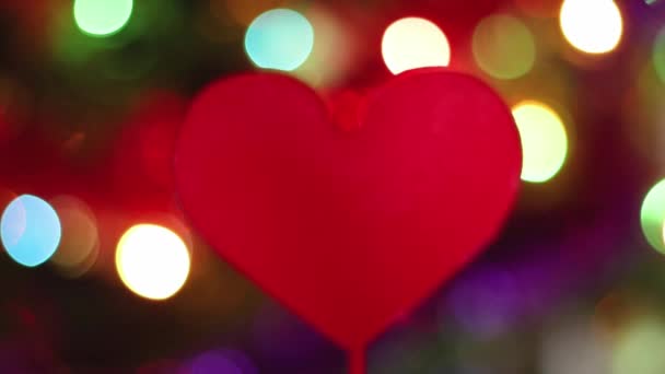 Dekor für den Valentinstag. Rotes Herz dreht sich vor dem Hintergrund von Lichtern. Feier des Tages der Verliebten. - Filmmaterial, Video