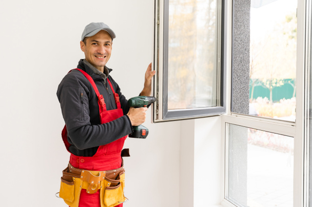 Bauarbeiter installiert neue Fenster im Haus - Foto, Bild