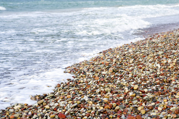 sea shore with colored pebbles, shoreline diagonally - Fotó, kép