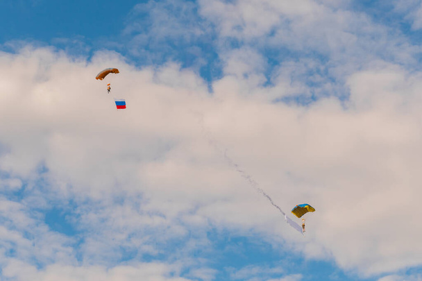 Two skydivers flying with parachute against blue sky - extreme sport concept - Foto, Imagem
