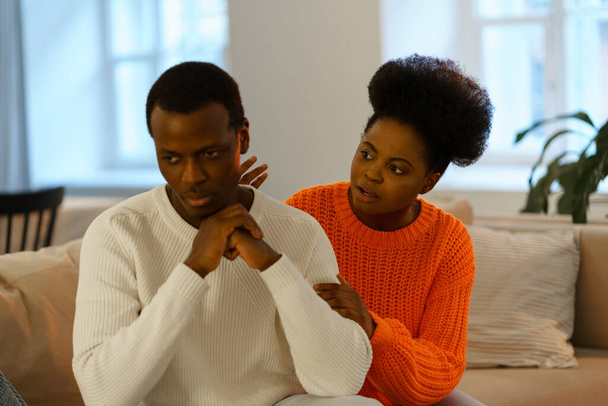 Ongelukkig Afrikaans getrouwd stel man en vrouw zitten op de bank thuis en proberen om relatie te herstellen - Foto, afbeelding