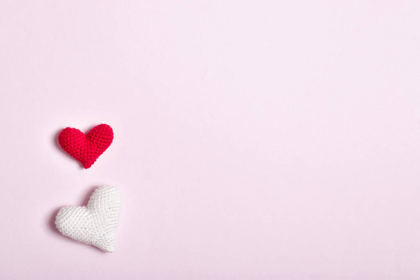 Two hearts lie on a pink background. Background for Valentines Day. Copy space. Flat lay, top view - 写真・画像