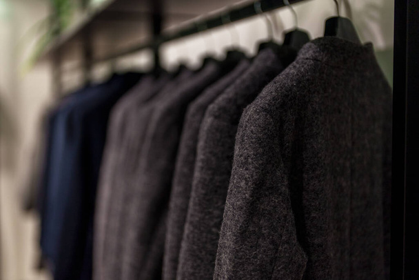 Colección de abrigo negro en tienda de ropa. - Foto, imagen