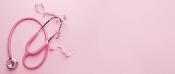 Pink ribbon and stethoscope on color background with space for text. Breast cancer awareness concept - Fotó, kép