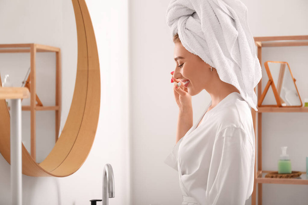 Güzel genç bir kadın sabah duşundan sonra dişlerini fırçalıyor. - Fotoğraf, Görsel