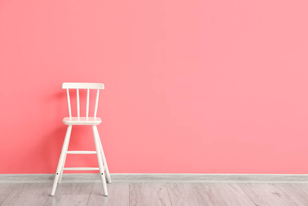 Witte stoel in de buurt van kleur muur in de kamer - Foto, afbeelding
