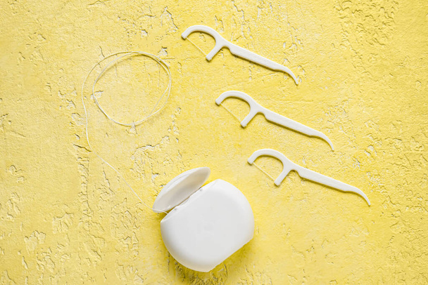 Dental floss with toothpicks on yellow background - Foto, Bild