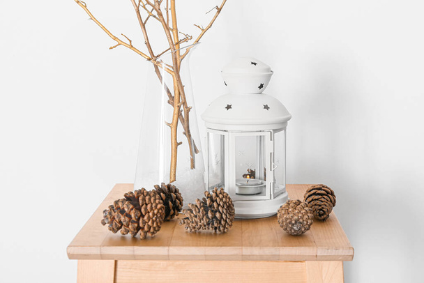 Pine cones and holder with candle on table in room - Foto, imagen