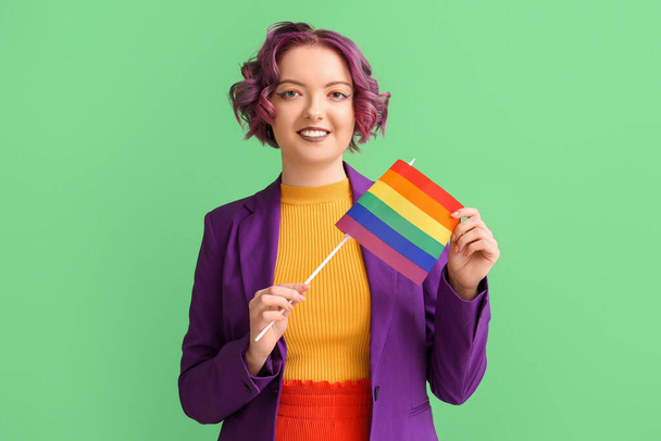 Mujer joven con bandera LGBT sobre fondo verde - Foto, Imagen